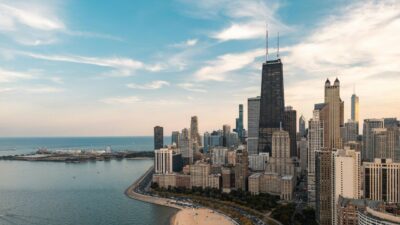 Chicago skyline along Lake Michigan with sandy beach and city buildings at sunset.