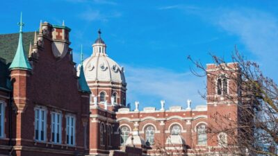 A historic brick building in Bucktown, Chicago with ornate domes and towers stands under a bright blue sky.