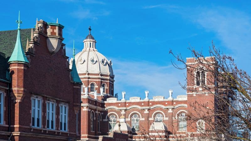 A historic brick building in Bucktown, Chicago with ornate domes and towers stands under a bright blue sky.