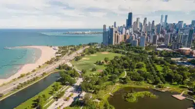 Aerial view of Chicago's lakefront parks, beach, and downtown skyline in summer.