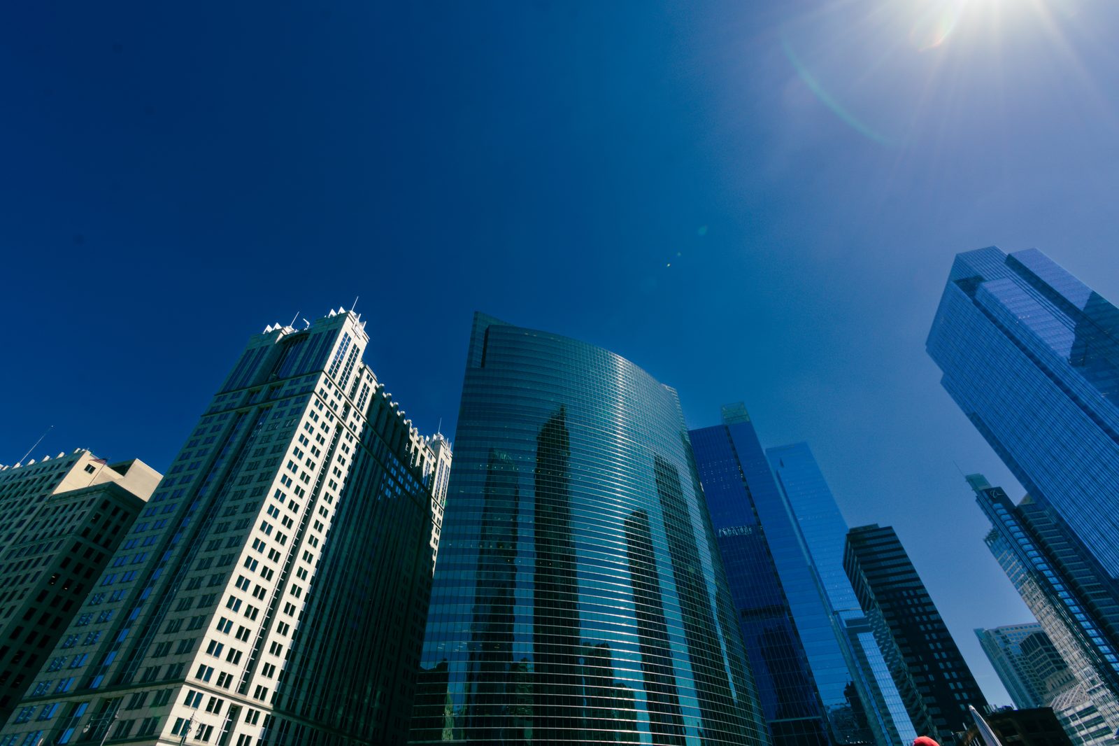 Looking up at Chicago glass high-rise towers against a blue sky
