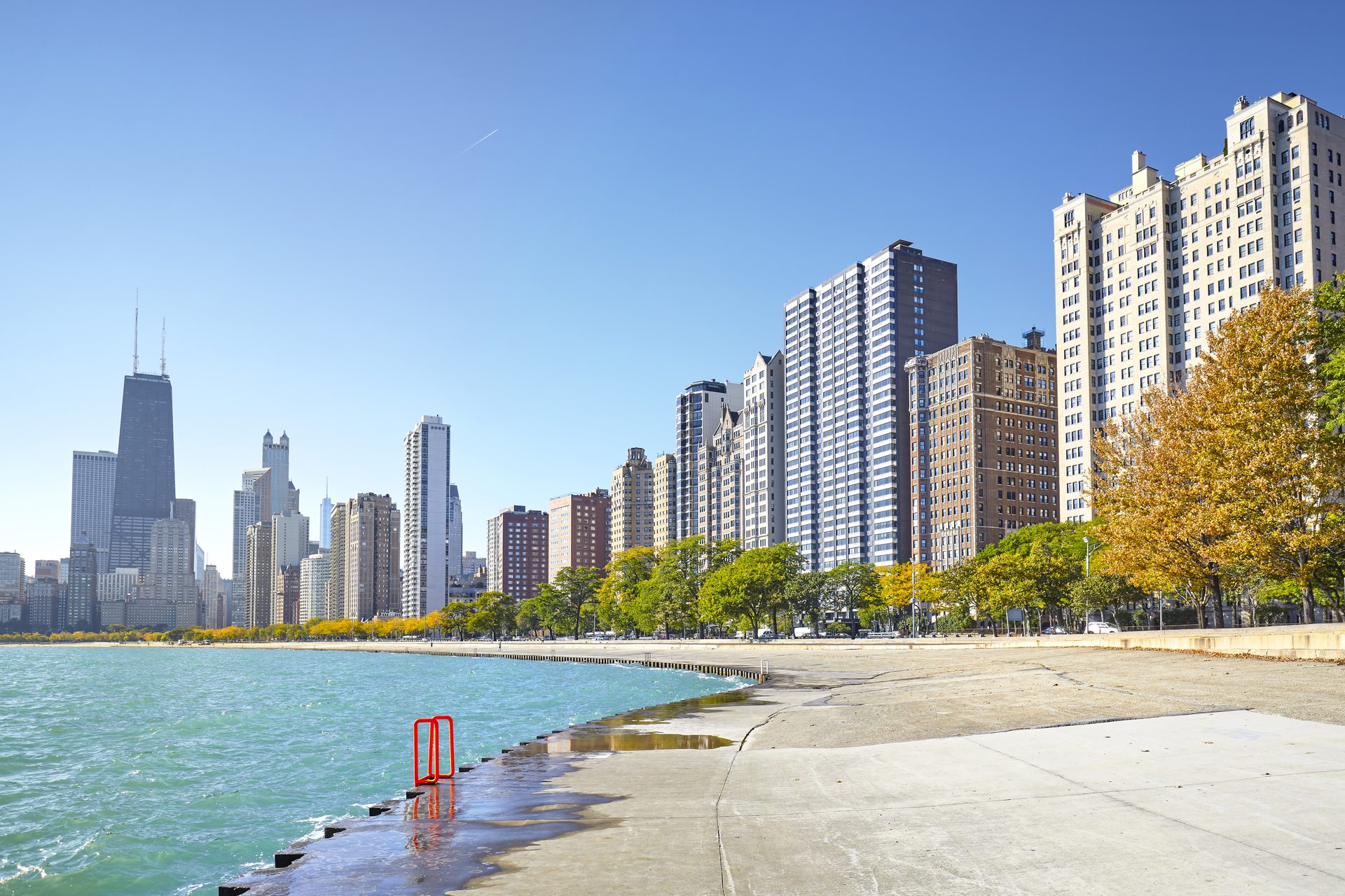 High-rise buildings lining the Chicago lakefront beside Lake Michigan on an early autumn morning.